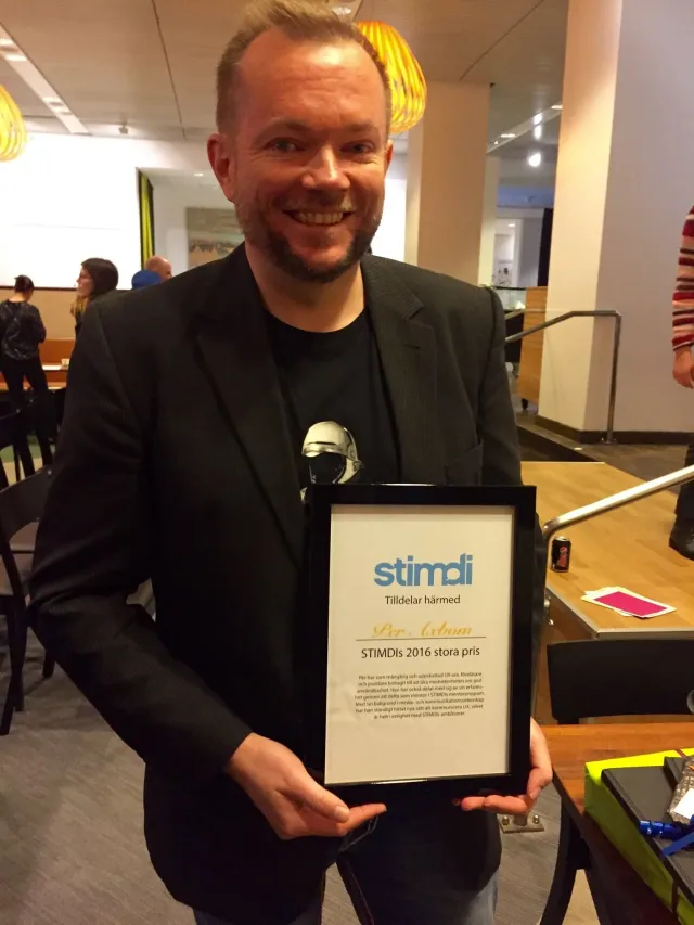 Per Axbom smiling, holding his framed diploma for STIMDI's 2016 Grand Prize.