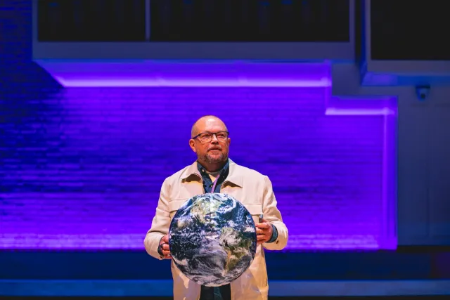 Per Axbom on stage holding an inflatable globe.